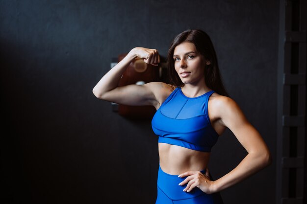 Fit woman posing on the camera. Personal trainer showing her form. Beauty of modern sport.