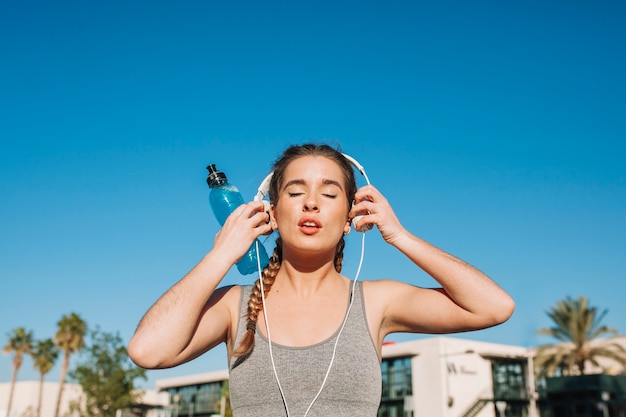 Fit woman putting on headphones