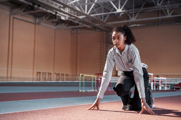 Fit woman ready to run in suit full shot