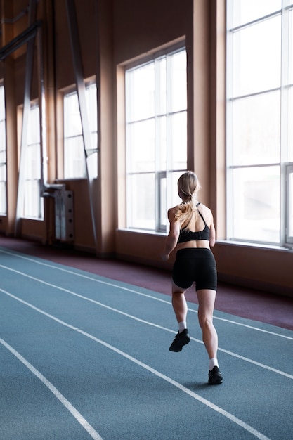 Fit woman running at gym full shot