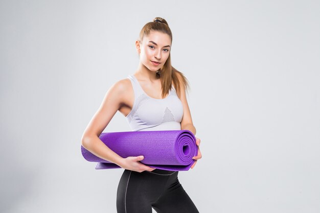 Fit woman with a gym mat isolated