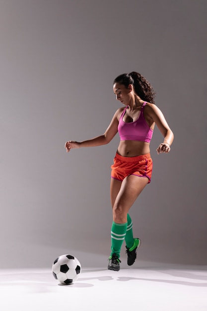 Подходящая женщина с футбольным мячом