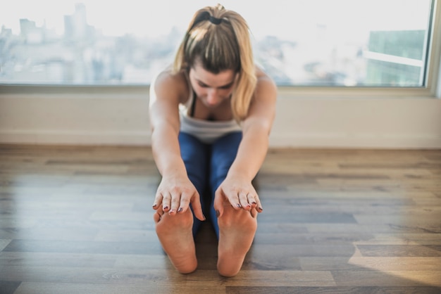 Free photo fit young girl doing stretching