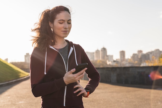 フィットの若い女性が彼女の電話をチェック