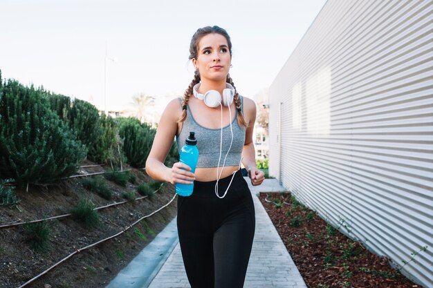 Fit young woman running on pavement