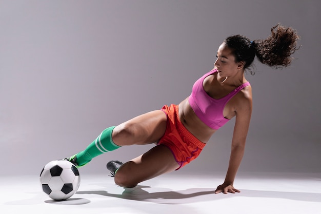 Foto gratuita giovane donna adatta con pallone da calcio