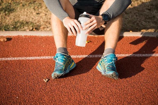 Free photo fitness boy holding bottle of water