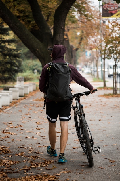 Фитнес мальчик с велосипедом в парке