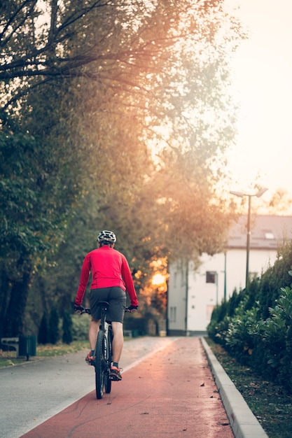 Fitness boy with bike on the road