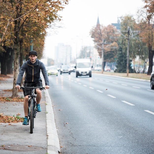 Fitness boy with bike on the road