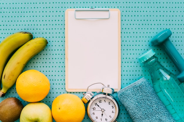 Fitness concept with clipboard clock and food