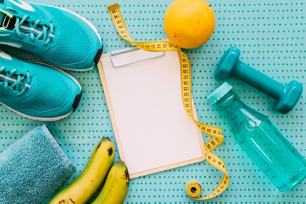 Fitness concept with clipboard, orange and shoes