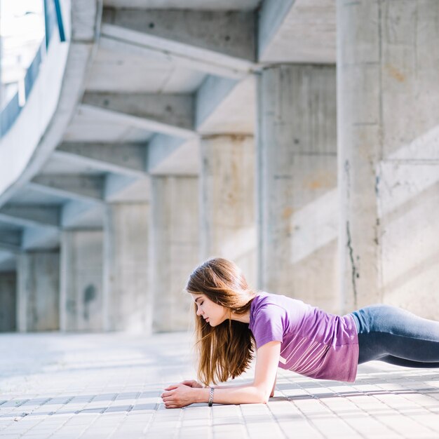 Fitness girl doing planking exercise outdoors