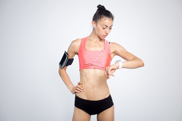 Fitness girl looking at smartwatch