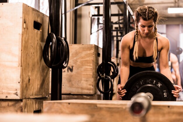 Fitness girl placing weight