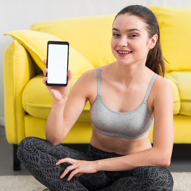 Fitness girl showing mobile phone