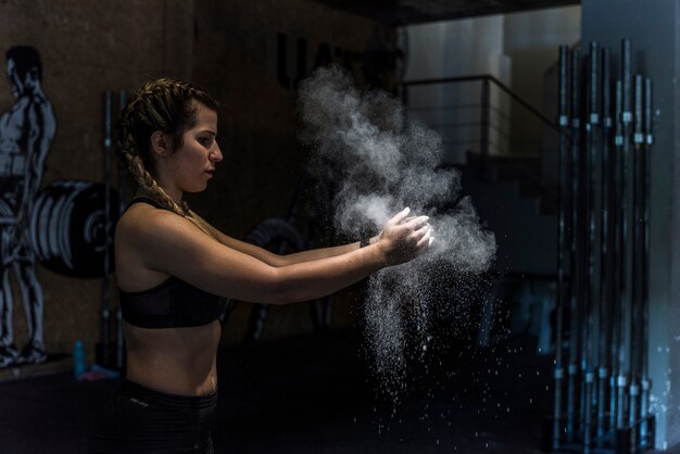 Ragazza di forma fisica con polvere nelle sue mani