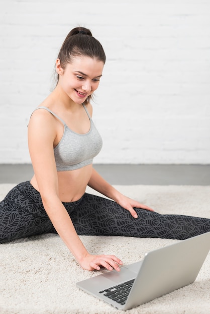 Ragazza di forma fisica che lavora con il computer portatile