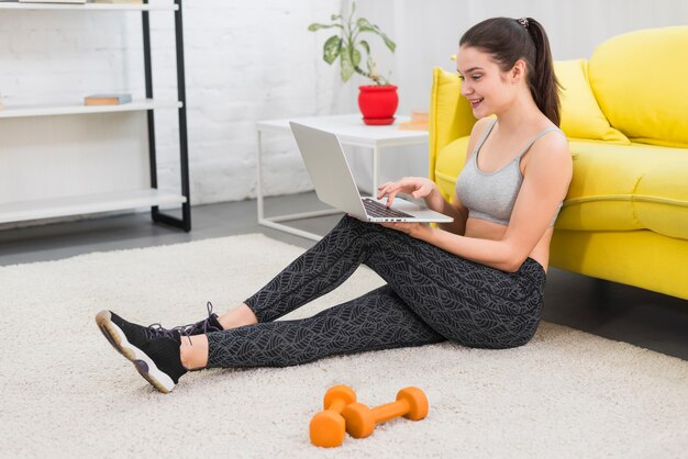 Fitness girl working with laptop