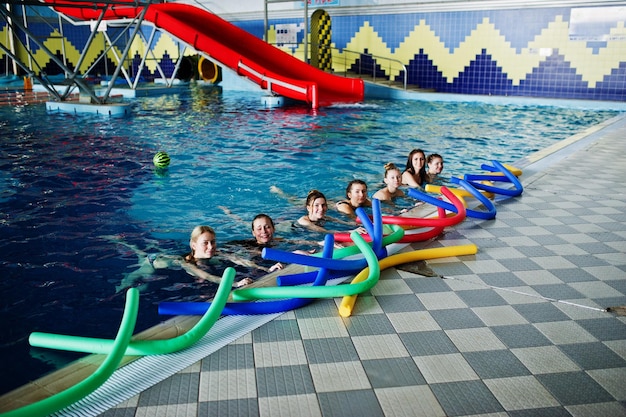 Fitness group of girls doing aerobical excercises in swimming pool at aqua park Sport and leisure activities