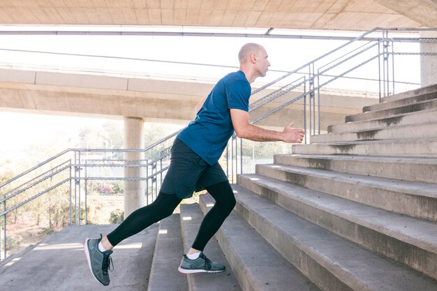 Fitness male athlete running on concrete staircase