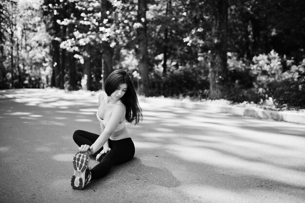 Fitness sport girl in sportswear sitting in road at park outdoor sports urban style