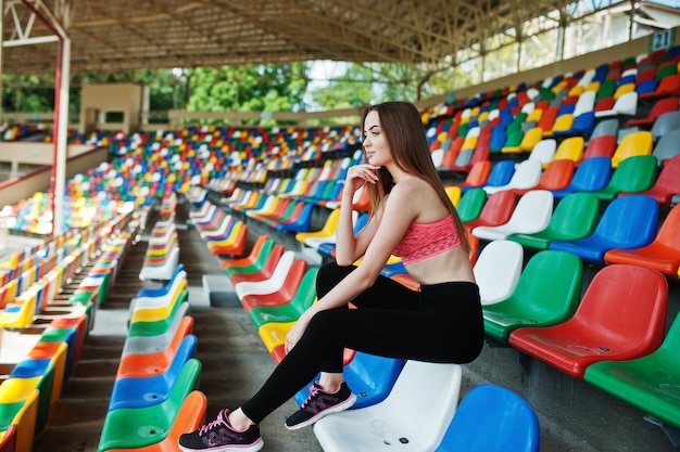 운동복에 피트 니스 스포티 한 소녀 경기장의 자 야외 스포츠에 앉아 행복 한 섹시 한 여자
