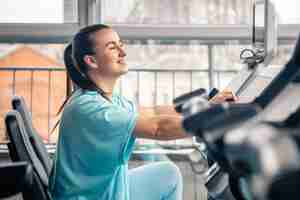 Free photo fitness woman on bicycle doing cardio workout at gym