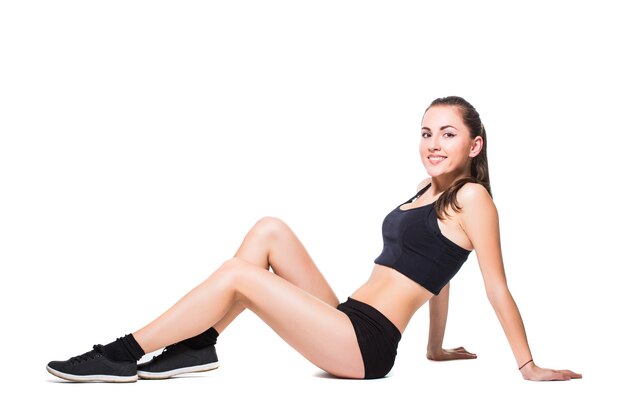 Женщина фитнеса делает упражнения на растяжку, изолированные на белом фоне