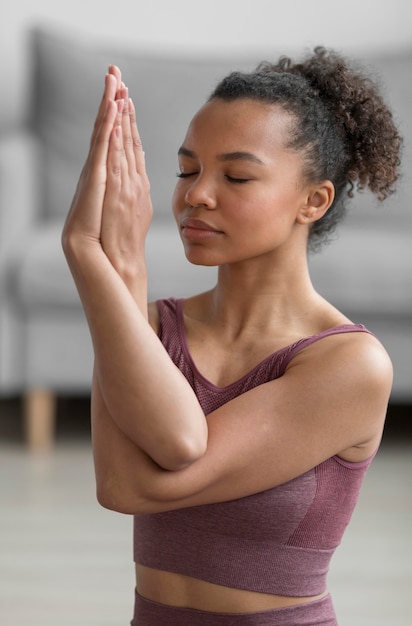 Donna di forma fisica che fa yoga a casa