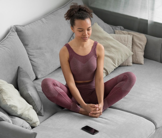 Donna di forma fisica che fa yoga a casa