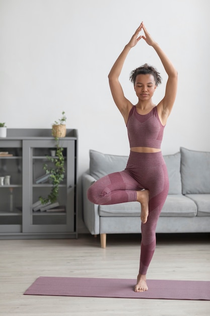 Fitness woman doing yoga on a yoga mat at home