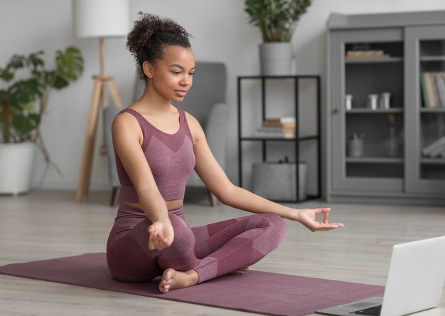 fitness woman doing yoga on a yoga mat at home