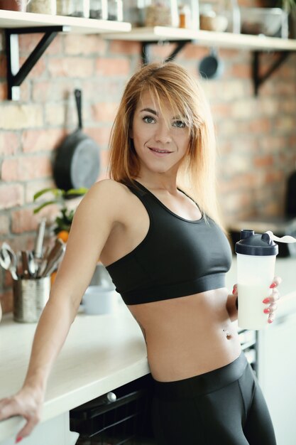 Fitness woman in kitchen