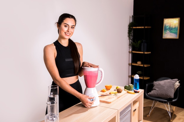 Foto gratuita donna di forma fisica che prepara un succo della disintossicazione