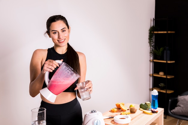 Foto gratuita donna di forma fisica che prepara un succo della disintossicazione