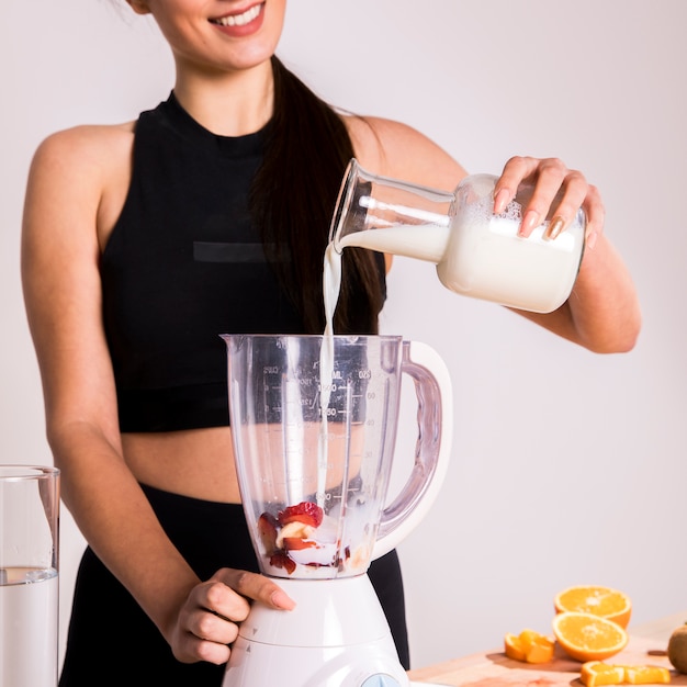 Foto gratuita donna di forma fisica che prepara un succo della disintossicazione