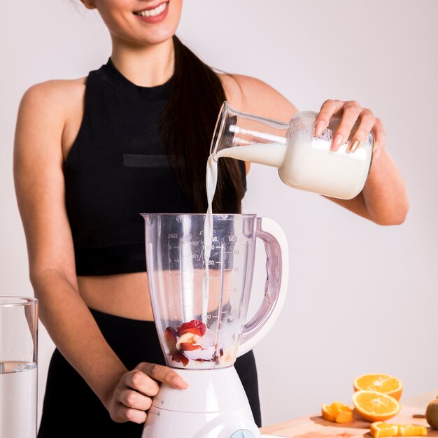 Фитнес женщина готовит детокс сок