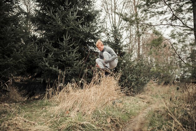 Фитнес молодой человек прыгает над травой