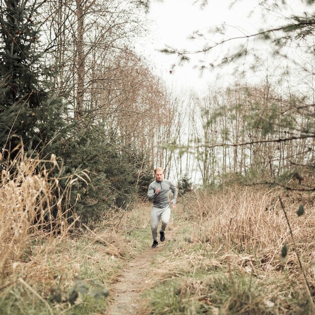 Fitness young man running on the forest trail