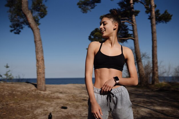 Fitness young woman walks in the park and posing for the camera