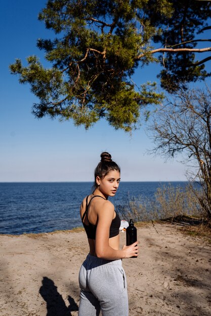 Fitness young woman walks in the park and posing for the camera