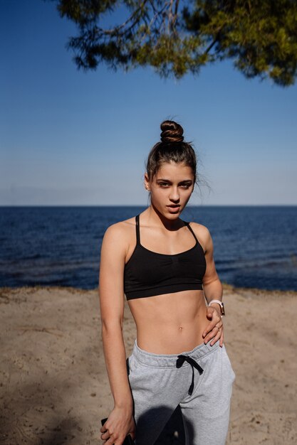 Fitness young woman walks in the park and posing