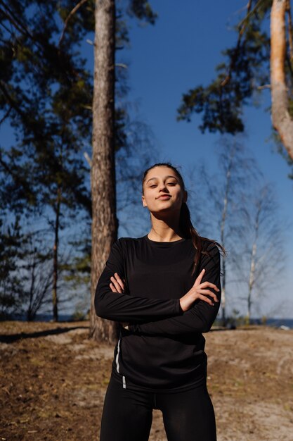 Fitness young woman walks in the park and posing