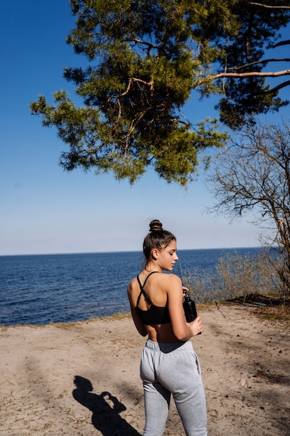 Foto gratuita giovane donna fitness cammina nel parco e in posa