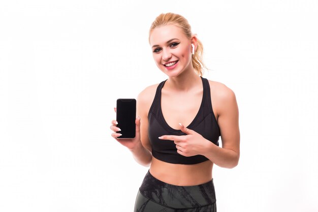Fitnessgirl показывает новый смартфон перед белым