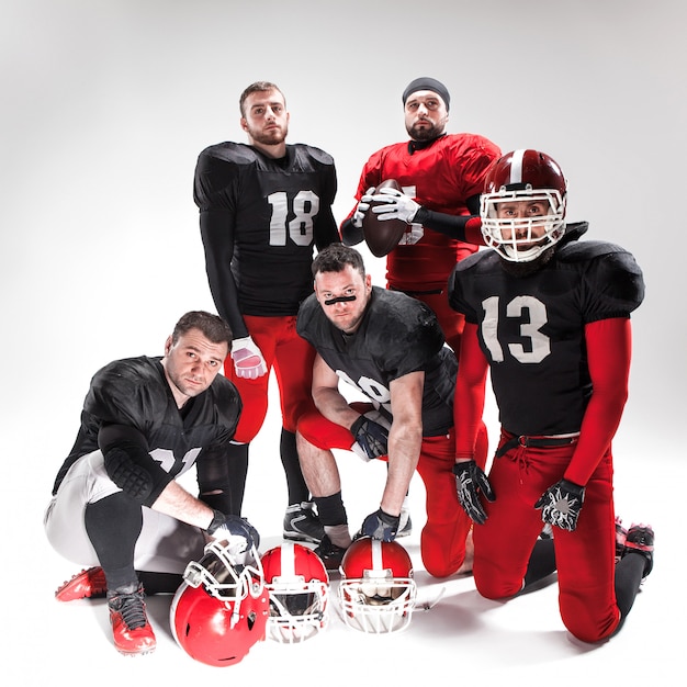 The five american football players posing with ball