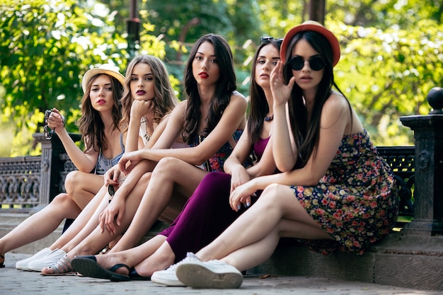 Free photo five beautiful young women posing in the park