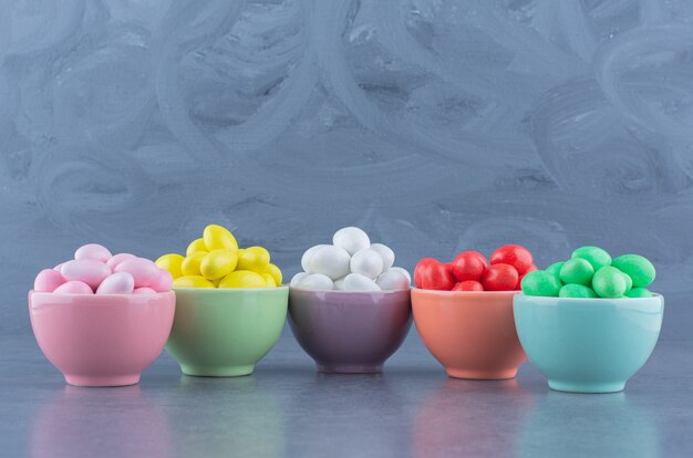 Five bowls of gum, on the marble surface