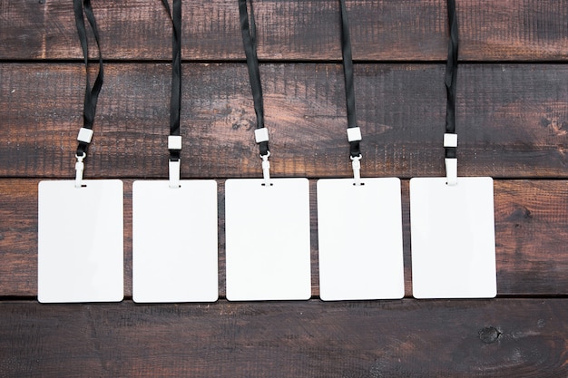 The five card badges with ropes on wooden table